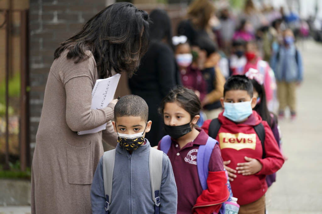 Virus Outbreak New Jersey Students wearing face masks line up to enter Christa McAuliffe School