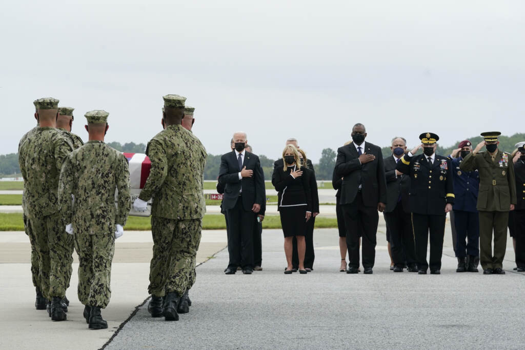 President Joe Biden watches as a Navy carry team moves a transfer case containing the remains of Navy Corpsman Maxton W. Soviak