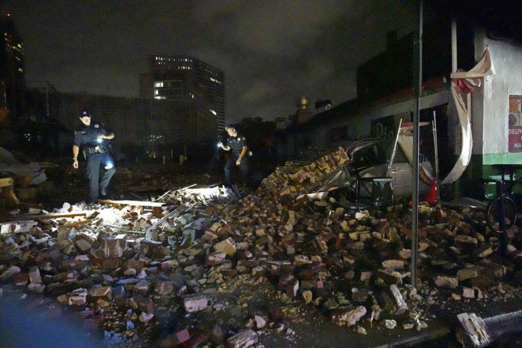 Tropical Weather Atlantic New Orleans Police detectives Adam Buckner, left, and Alexander Reiter, look over debris from a building that collapsed during Hurricane Ida in New Orleans, Monday, Aug. 30, 2021. Hurricane Ida knocked out power to all of New Orleans and inundated coastal Louisiana communities on a deadly path through the Gulf Coast that is still unfolding and promises more destruction. (AP Photo/Gerald Herbert)