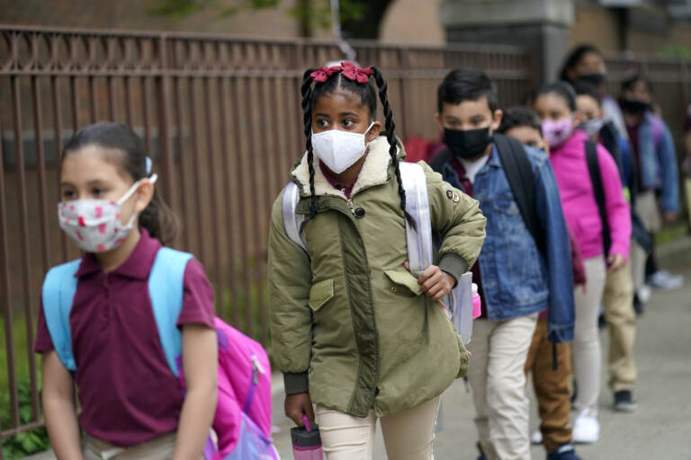 Students line up to enter Christa McAuliffe School while wearing masks
