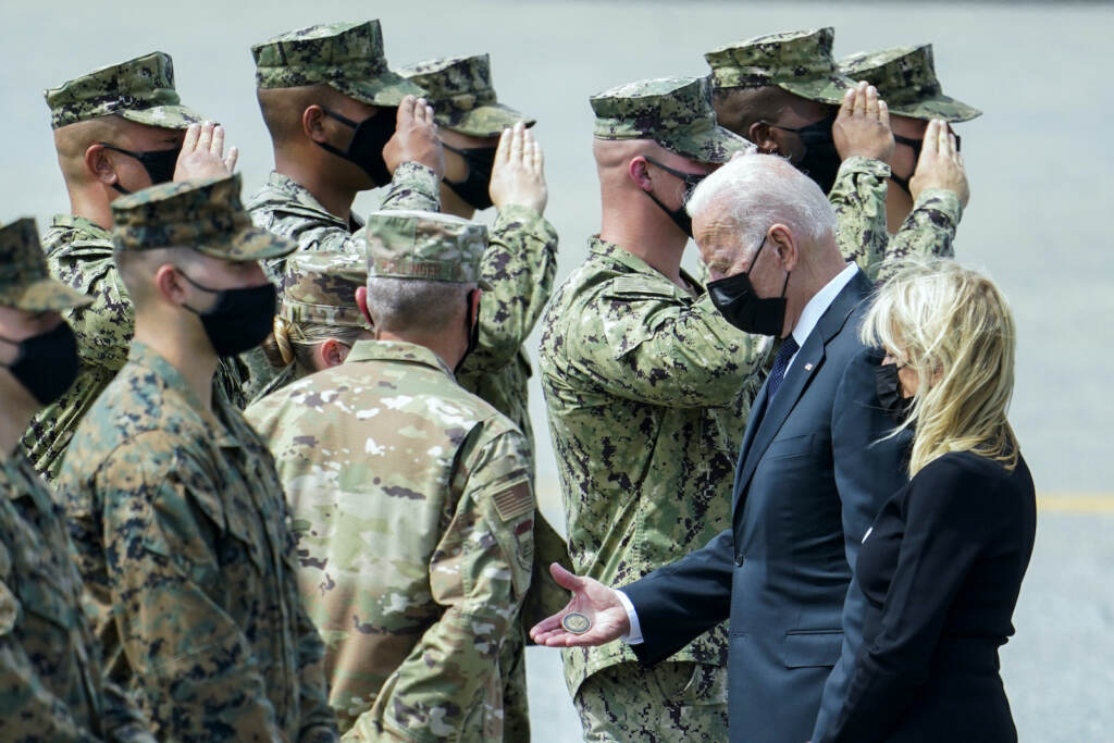 Joe Biden, Jill Biden President Joe Biden holds a presidential challenge coin as he is surrounded by Air Force officers