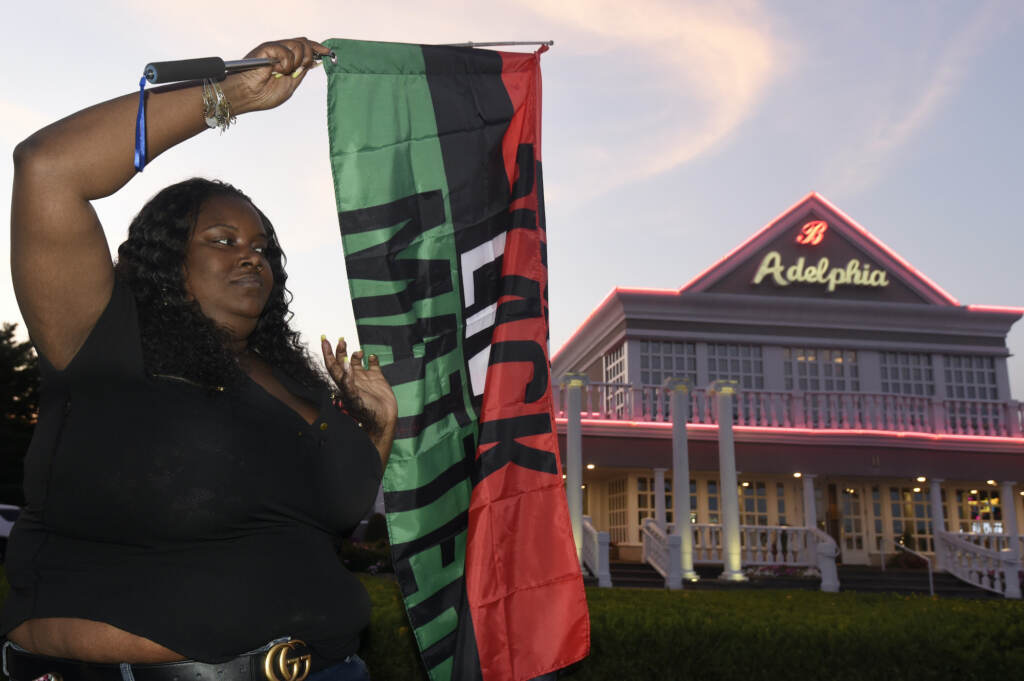 Clarkiya Wilson waves a Black Lives Matter flag outside Adelphia restaurant