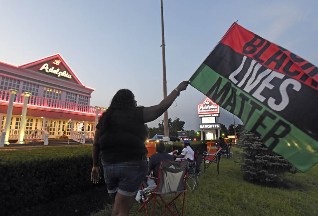 Clarkiya Wilson waves a Black Lives Matter flag outside Adelphia restaurant