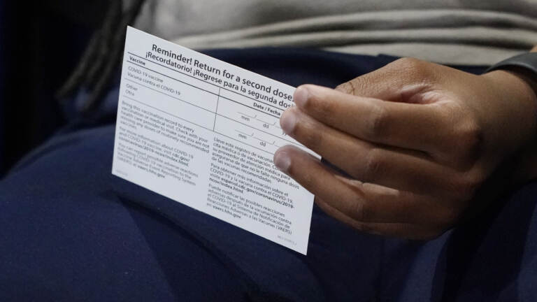 Jniya Tallie fiddles with her vaccination card