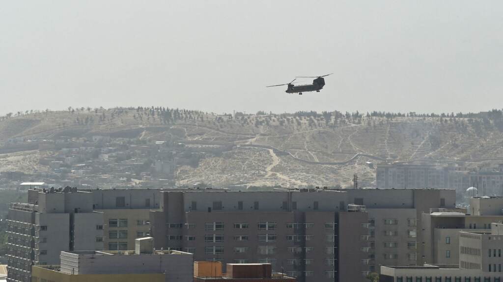 A U.S. military helicopter is pictured flying above the U.S. Embassy in Kabul on Sunday. The Taliban swept into Kabul, facing little resistance. A U.S. military helicopter is pictured flying above the U.S. Embassy in Kabul