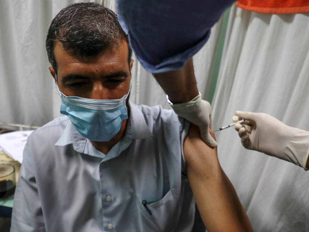Virus Outbreak Palestine A medic administers a dose of the Pfizer-BioNTech COVID-19 vaccine