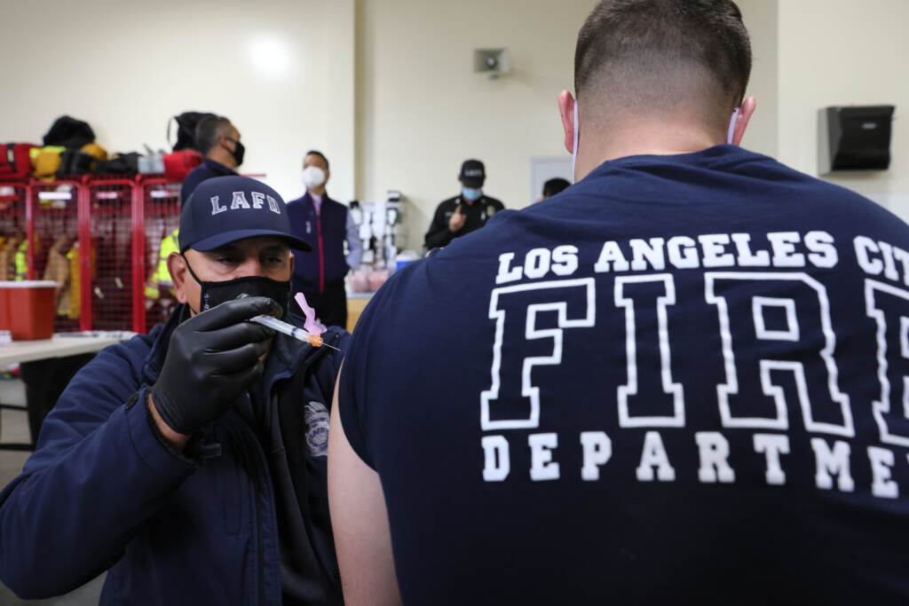 LA Firefighters Inoculated With Covid-19 Vaccine A health worker administers a COVID-19 vaccine to a fire department worker