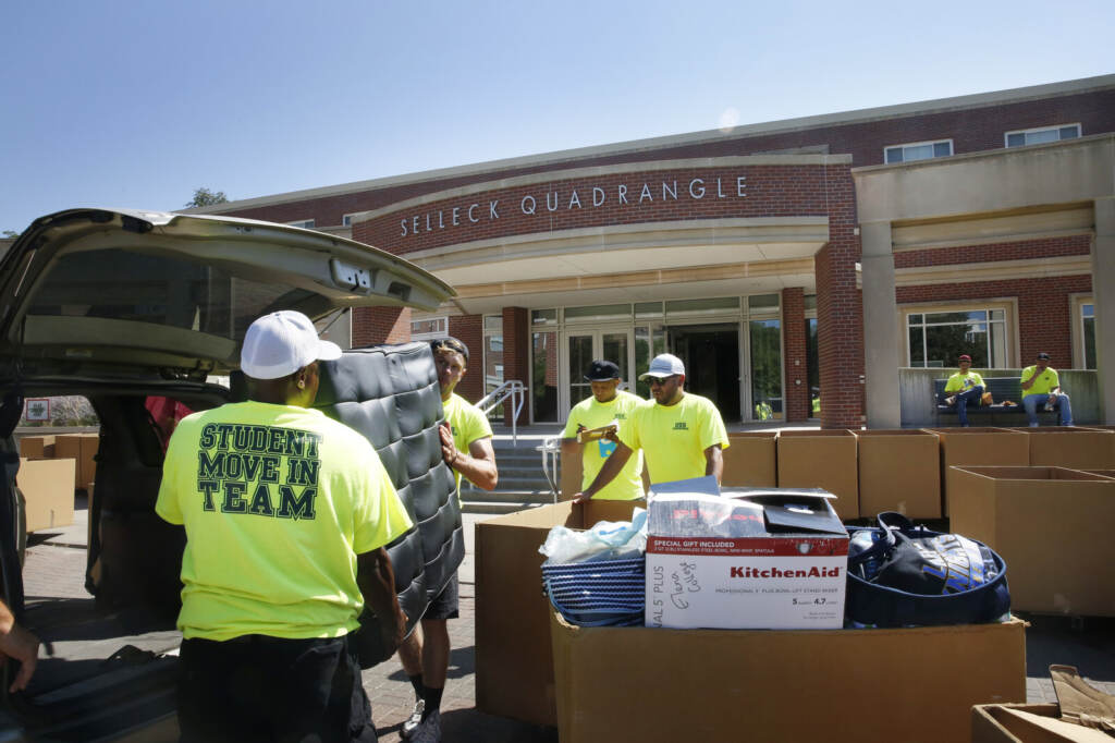 Workers help students move in to Selleck Hall