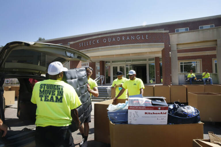 Workers help students move in to Selleck Hall