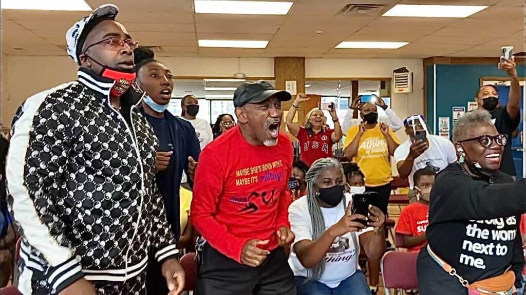 Athing Mu is cheered to victory in the 800 meters at the Tokyo Olympics by her high school coaches (from left) Nigiel Boone and Al Jennings,