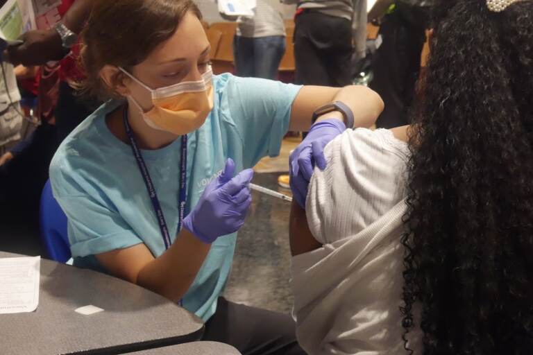 A student receives her vaccine at West Philly's Back to School JAM. (Luisa Suarez/WHYY)