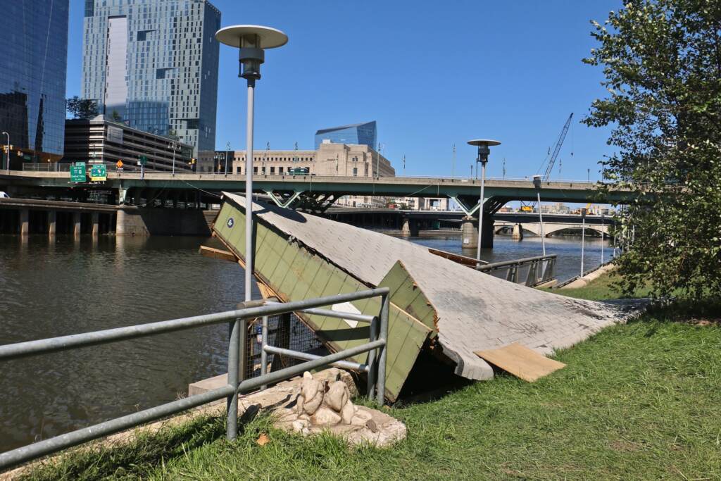 The roof of a shed rests on a railing along the Schuylkill River Trail
