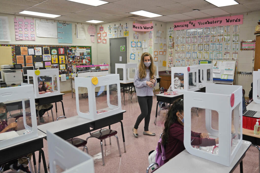 Maria Mirkovic works with some of her third graders in her classroom