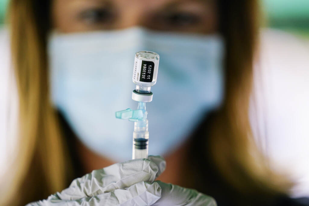 Virus Outbreak A syringe is prepared with the Pfizer COVID-19 vaccine