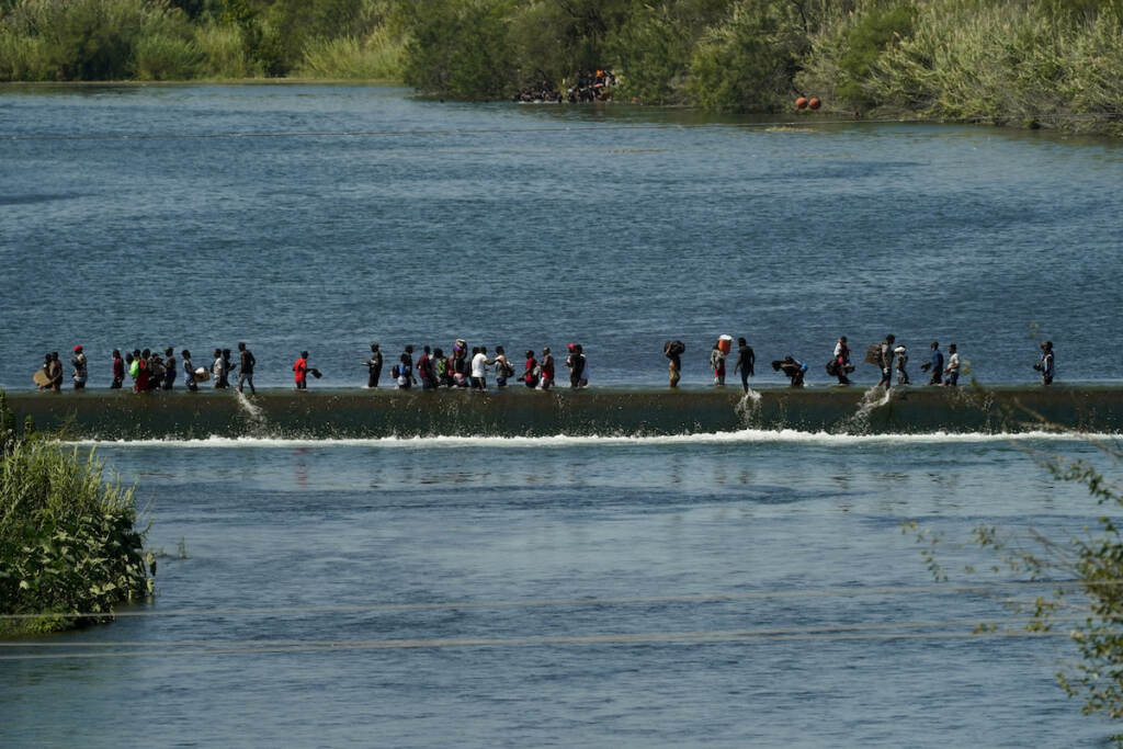 Border Migrant Camp Haitian migrants use a dam to cross to and from the United States from Mexico, Friday, Sept. 17, 2021, in Del Rio, Texas