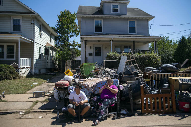 N.J. residents sit alongside belongings damaged by the remnants of Hurricane Ida outside their home