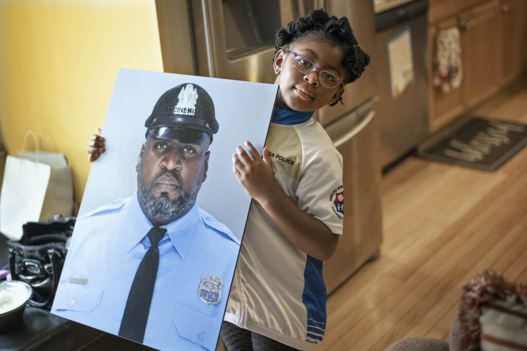 Virus Outbreak First Responders Vaccines Amethyst holds a photo of her father