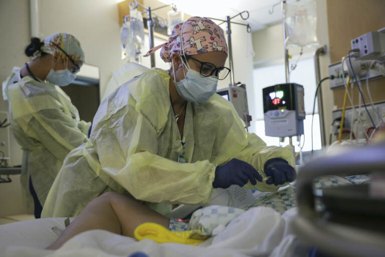 A critical care nurse administers an anti-viral medication to a COVID-positive patien