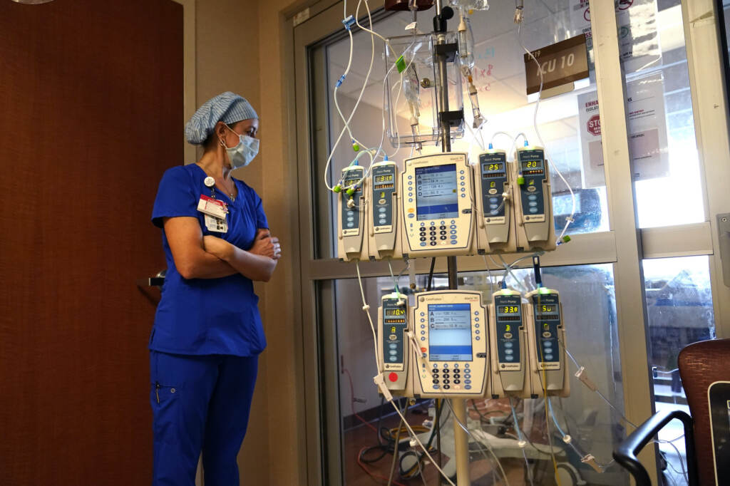 Virus Outbreak US Beth Springer looks into a patient's room in a COVID-19 ward