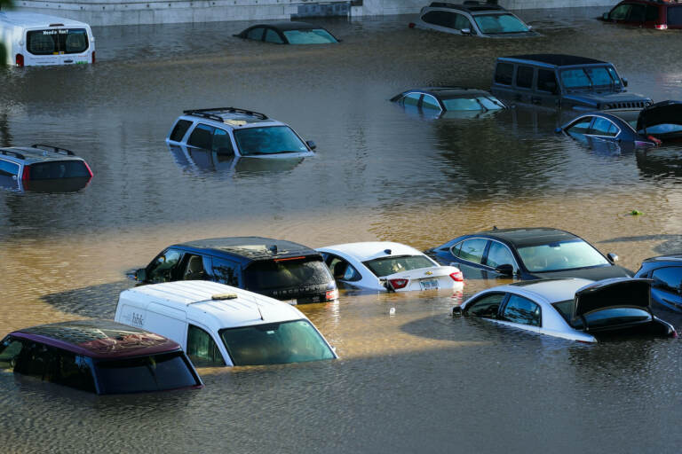 Vehicles are under water during flooding in a Philly parking lot
