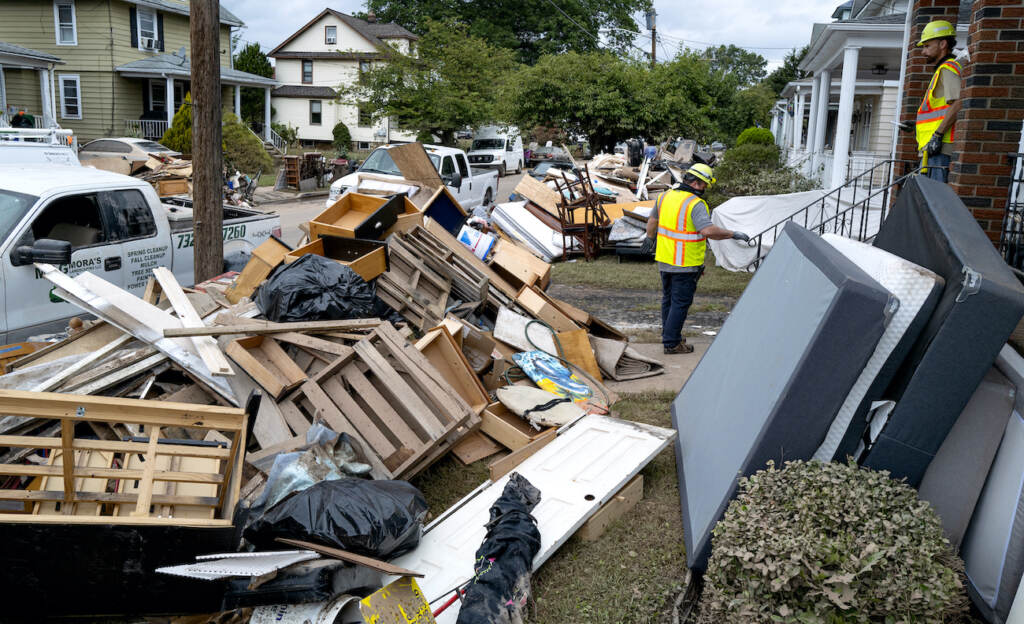 Tropical Weather Atlantic Utility workers work among debris from flood damage