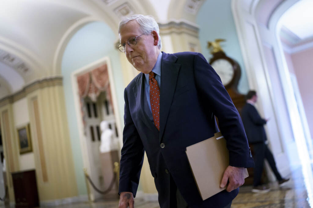 Mitch McConnell Senate Minority Leader Mitch McConnell walks while holding a folder