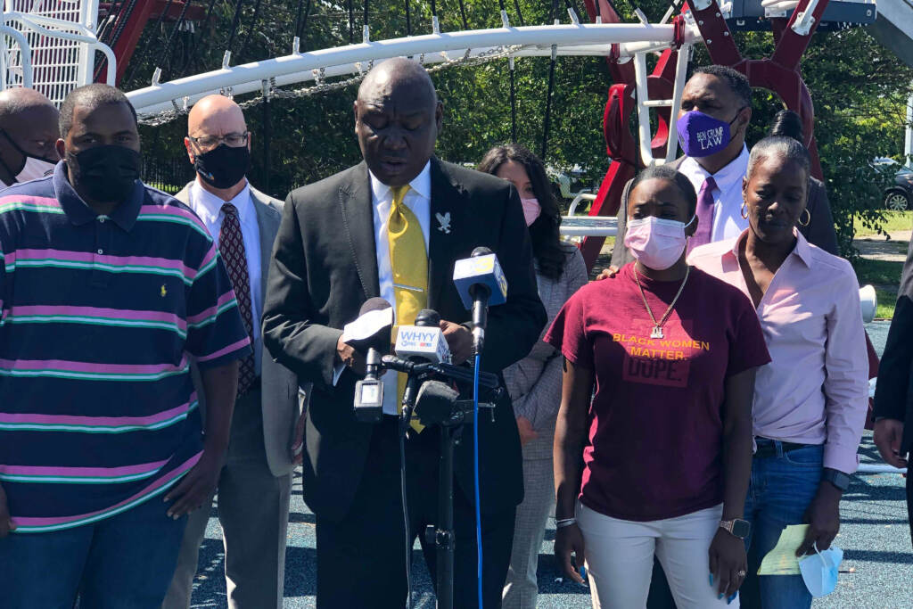 Image-from-iOS-(193) Attorney Ben Crump joined by Micah “Dew” Tennant’s parents Samuel Dunmore (left) and Angela Tennant along with Micah’s aunt Monica Tennant (far right) as he announces a lawsuit against the Pleasantville Board of Education and NJSIAA. (P. Kenneth Burns/WHYY)