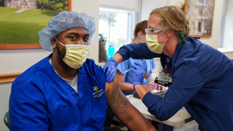 Kaylin Satterfield, a Christiana Care health aide, gets the COVID-19 vaccine on Thursday from nurse manager Elizabeth Intermoia at Wilmington Hospital. (Courtesy of ChristianaCare)