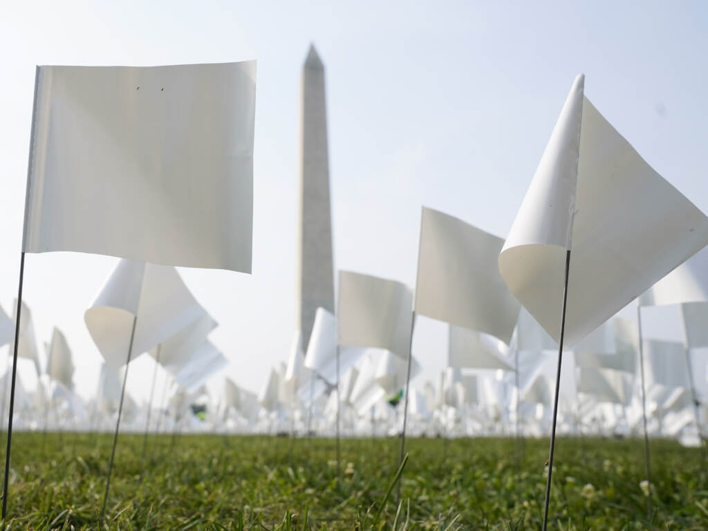 White flags stand near the Washington Monument on Tuesday. The flags, which will number more than 630,000 when the temporary art installation on the National Mall is completed, are part of artist Suzanne Brennan Firstenberg's In America: Remember, honoring Americans who have died of COVID-19. (Patrick Semansky/AP)