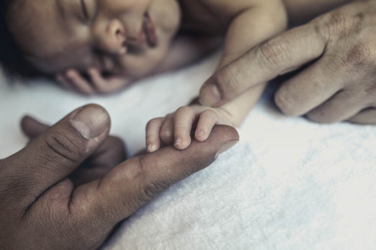 Baby holding parents hands