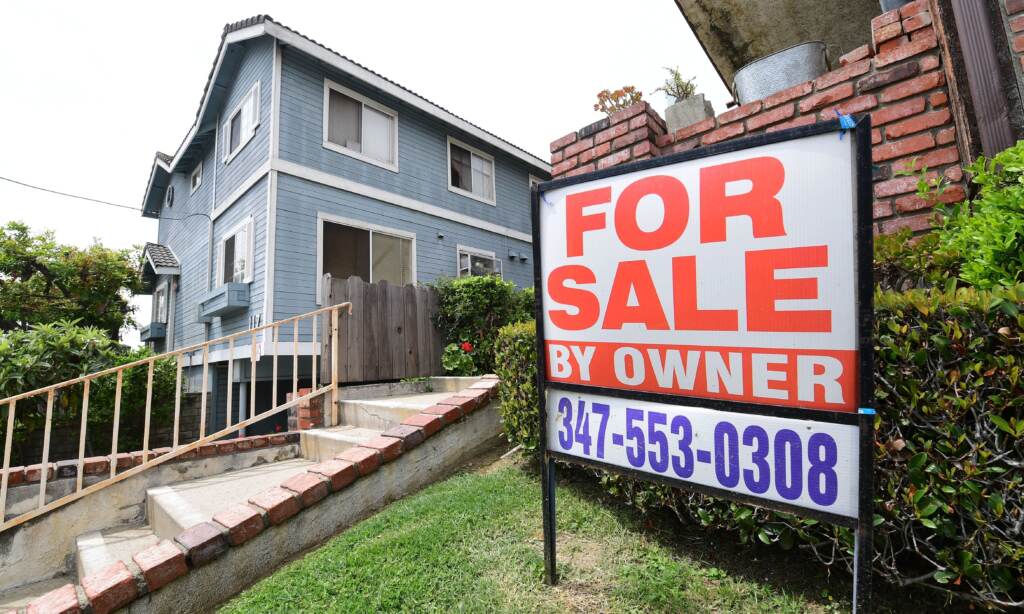 A “For Sale by Owner” sign is posted in front of property in Monterey Park, Calif., in April 2020. A
