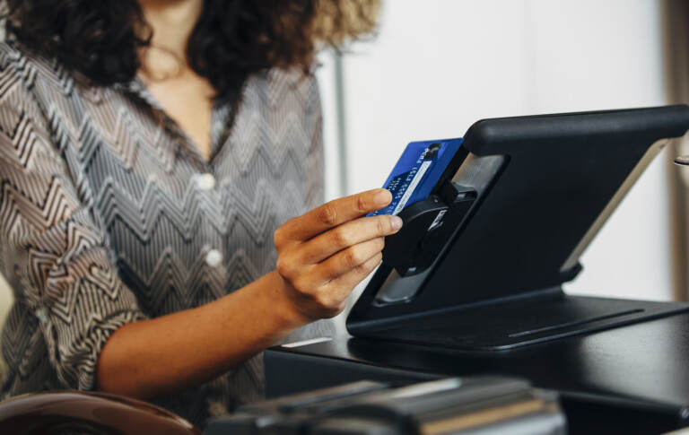 A cashier swipes a credit card at a register.