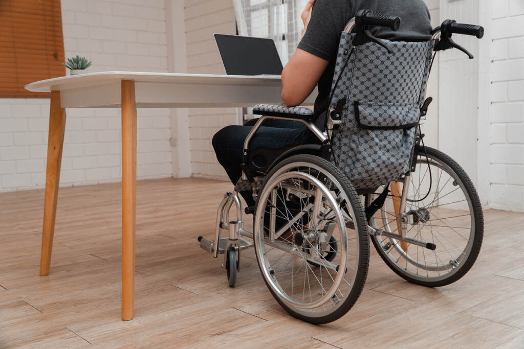 Happy Disabled Asian Man Sitting In A Wheelchair And Working Wit (Prot56/Bigstock)