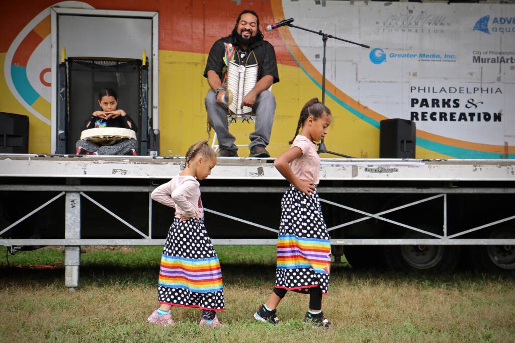 2021 10 11-elee-tyron ellis-philadelphia penn treaty park-indigenous peoples day Kai'Lyn Ellis, 5, and her sister, Li'Ana Ellis, 10, members of the Nanticoke Lenape tribe, perform a toe dance while their father, Tyron Ellis chants at Philadelphia's Indigenous Peoples Day celebration at Penn Treaty Park. (Emma Lee/WHYY)