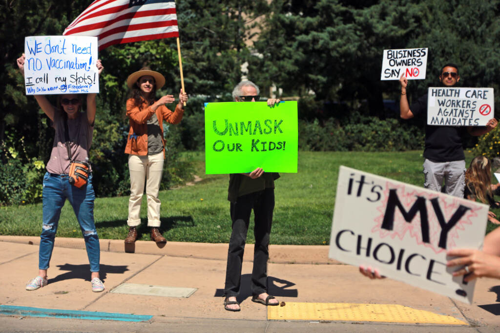 Facebook Papers Misinformation Vaccines Protesters hold signs denouncing vaccine and mask mandates
