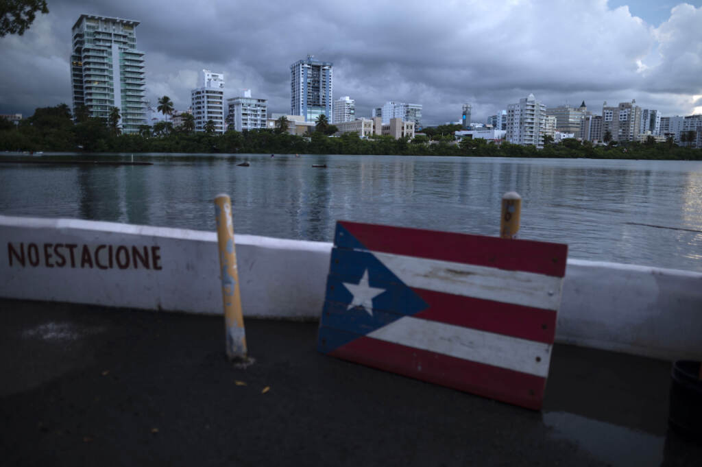 Puerto Rico Darkened Island A wooden Puerto Rican flag lies on the shore of the Condado lagoon, where multiple selective blackouts have been recorded in the past days, in San Juan, Puerto Rico, Thursday, Sept. 30, 2021. Power outages across the island have surged in recent weeks, with some lasting up to several days. (AP Photo/Carlos Giusti)