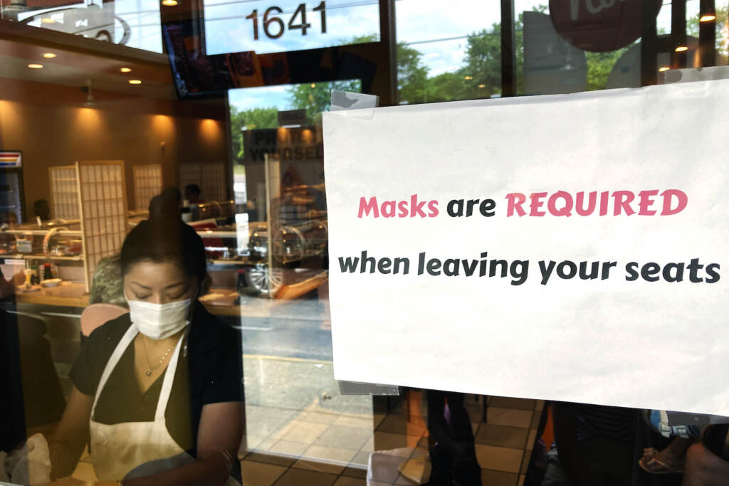 Small Business Return of Restrictions FILE - In this June 17, 2021, file photo, a sign requiring masks is displayed at a restaurant in Rolling Meadows, Ill. (AP Photo/Nam Y. Huh, File)