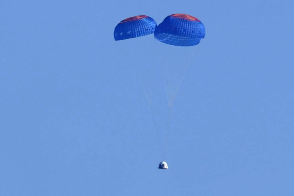 Parachutes carry the Blue Origin's capsule with passengers William Shatner, Chris Boshuizen, Audrey Powers and Glen de Vries from its spaceport near Van Horn, Texas, Wednesday, Oct. 13, 2021