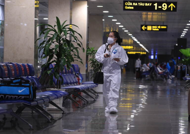 A passenger in full protective suit walks to boarding gate at Tan Son Nhat airport in Ho Chi Minh city, Vietnam on 15 Oct. 2021. Vietnam has resumed air travel after several months of suspension due to COVID-19 outbreak