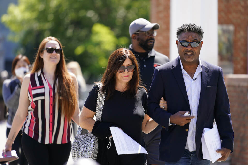 File photo: Former NFL players Ken Jenkins, right, and Clarence Vaughn III, center right, along with their wives, Amy Lewis, center, and Brooke Vaughn, left, carrie tens of thousands of petitions demanding equal treatment for everyone involved in the settlement of concussion claims against the NFL, to the federal courthouse in Philadelphia, Friday, May 14, 2021