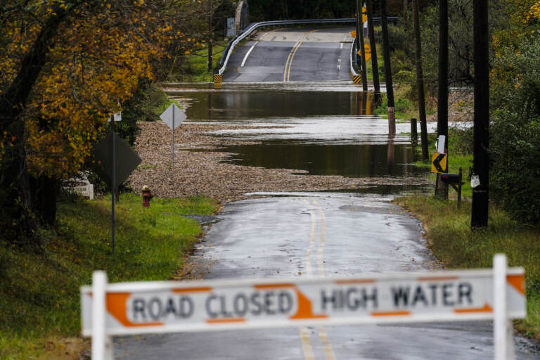 A barricade blocks access to a road flooded by recent rain in Branchburg, N.J., Tuesday, Oct. 26, 2021