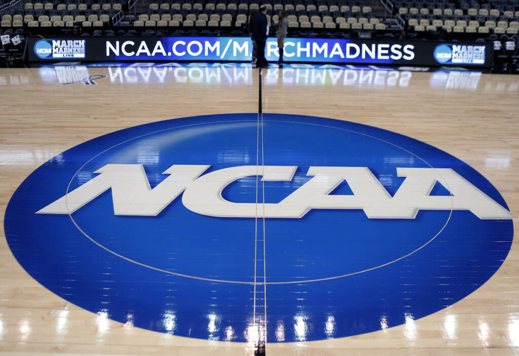 NCAA Logo In this March 18, 2015, file photo, the NCAA logo is displayed at center court as work continues at The Consol Energy Center in Pittsburgh.