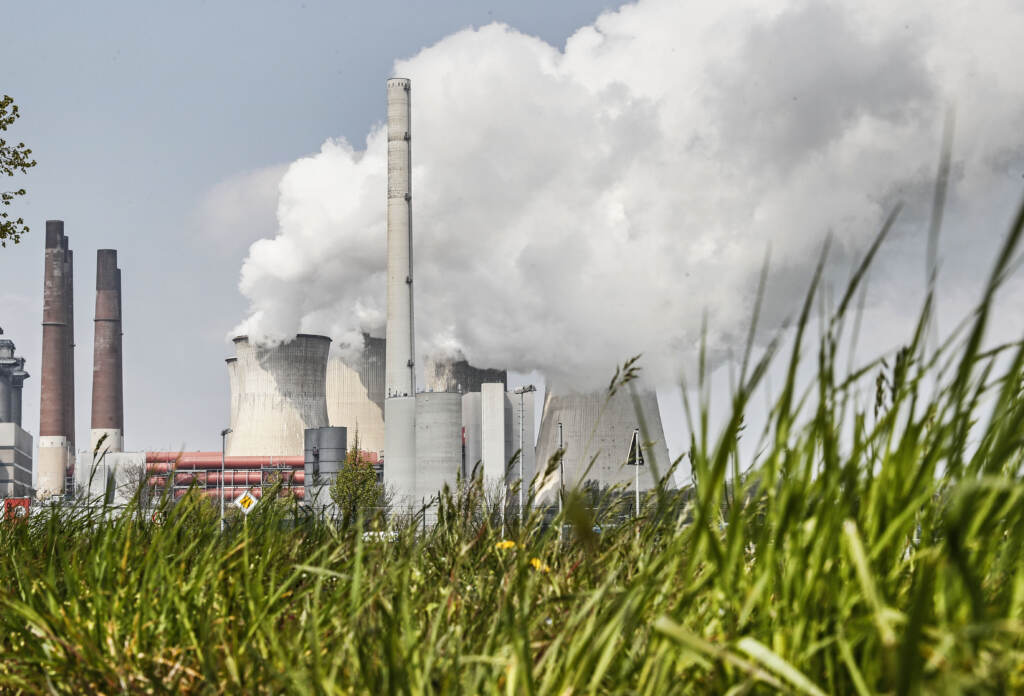A coal-fired RWE power plant steams on a sunny day