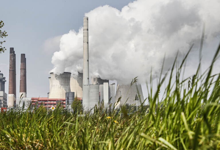 A coal-fired RWE power plant steams on a sunny day