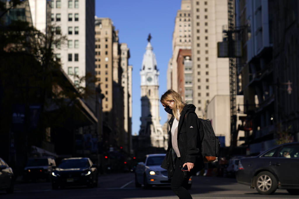Virus Outbreak Pennsylvania A woman wearing a face mask crosses Broad Street
