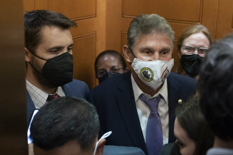 Sen. Joe Manchin, D-W.Va., squeezes into an elevator with White House domestic policy adviser Susan Rice, center, Director of the National Economic Council Brian Deese, left, and other White House officials