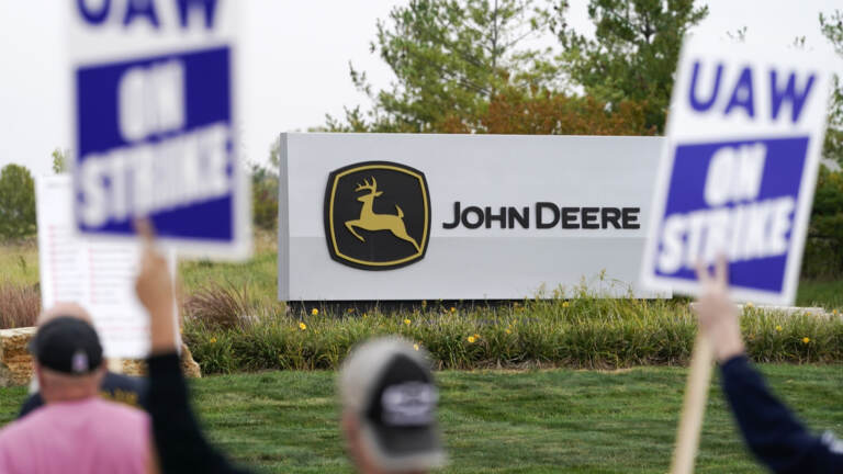 FILE - Members of the United Auto Workers strike outside of a John Deere plant, Wednesday, Oct. 20, 2021, in Ankeny, Iowa.  The farm equipment manufacturer reached a tentative labor agreement Saturday, Oct. 30,  with the United Auto Workers union.  But a UAW strike that began Oct. 14 will continue -- and details of the proposed contract will not be released -- while workers study the terms of the agreement in advance of a vote.  (AP Photo/Charlie Neibergall, File)