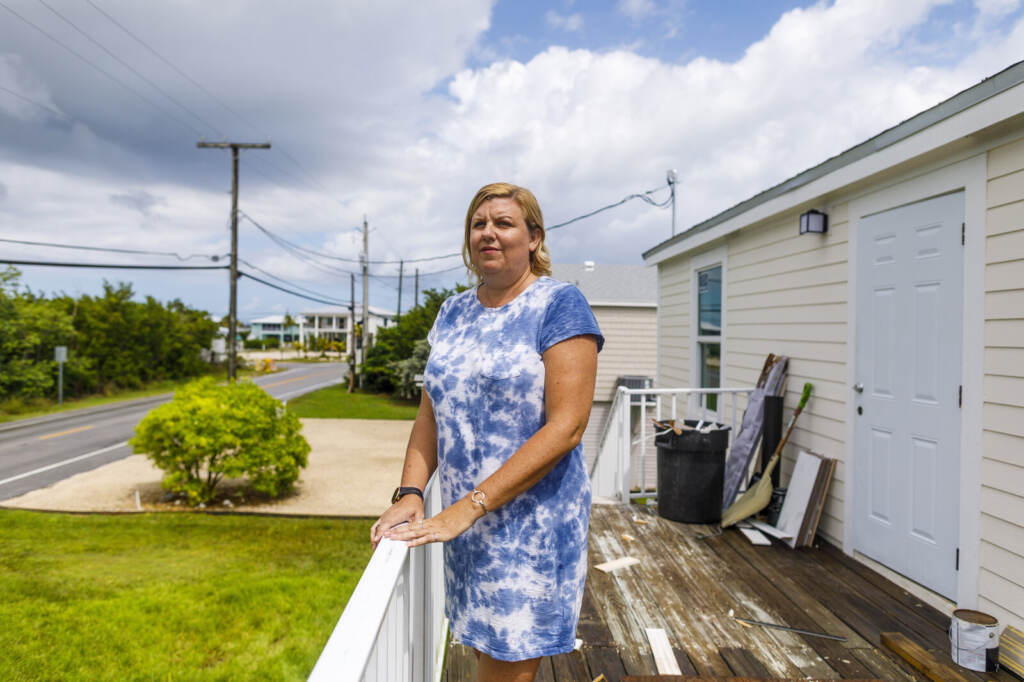Amy Tripp stands on the deck of her new home