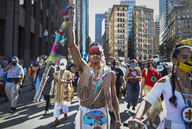 A demonstrator marches to Faneuil Hall with other protesters while participating in the Indigenous Peoples Day rally and march in Boston on Oct. 10, 2020. (Photo by Erin Clark/The Boston Globe via Getty Images)