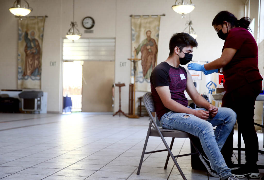 A person receives the Pfizer COVID-19 vaccine at a clinic at St. Patrick’s Catholic Church in Los Angeles in April. A person receives their first dose of the Pfizer COVID-19 vaccine at a clinic targeting minority community members at St. Patrick's Catholic Church on April 9, 2021 in Los Angeles, California. (Photo by Mario Tama/Getty Images)